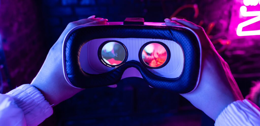 Person holding VR goggles representing virtual reality in online casino gaming